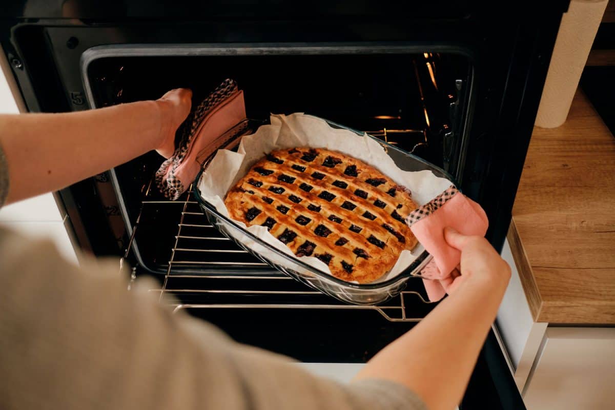 A woman cooking a delicious bake jem pie out of the oven
