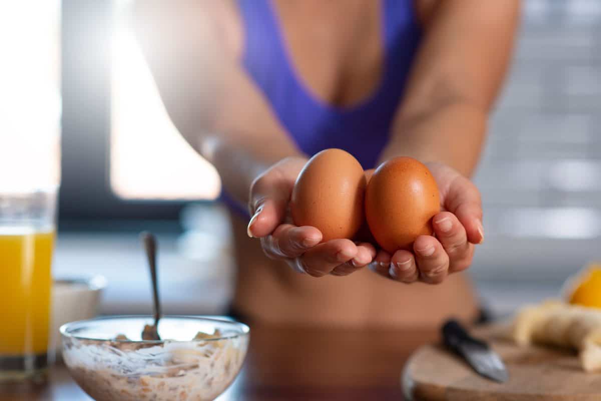 A woman weighing two organic eggs on her hands