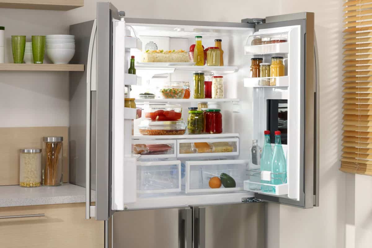 An opened double door fridge containing lots of cooking essentials