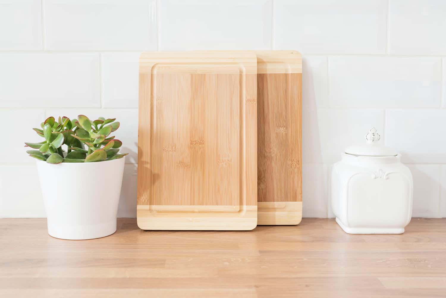 Bright And Clean Modern Minimalist Kitchen, Close Up. Cutting Boards, Green Succulent Pot On A Wooden Worktop