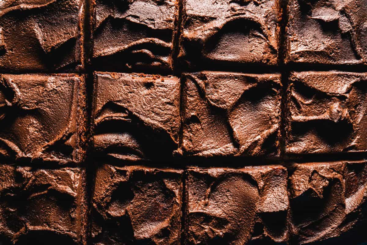 Close-up of brownie chocolate cake in square slices macro with textured surface