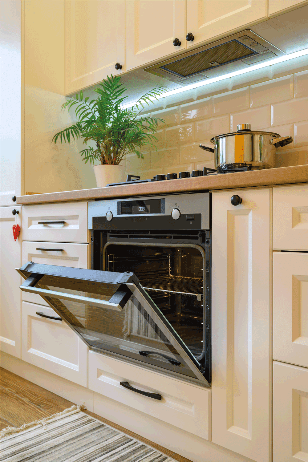 Cozy modern kitchen interior, closeup to open oven's door