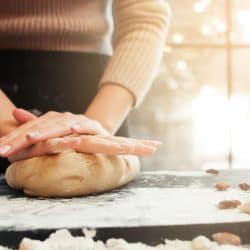 Female hands kneading dough, sunset background, Can You Make Bread Without Sugar?