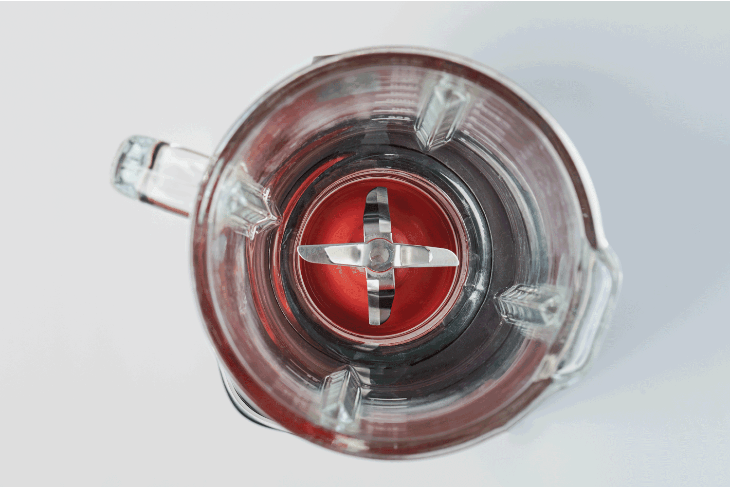 Glass cup with blades of mixer above top view 