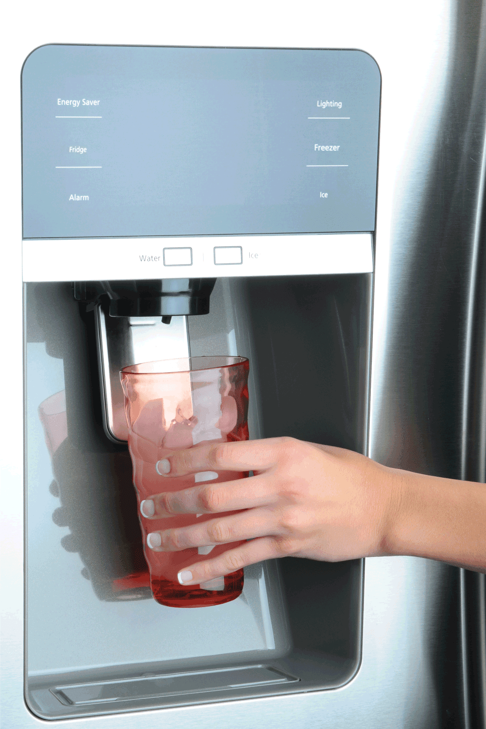 Hand holding drink is pressing on button to get fresh ice form refrigerator.