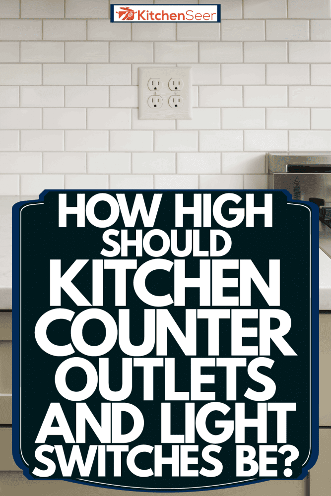 A photo of a white kitchen countertop, light gray kitchen cabinets and a socket on the backsplash, How High Should Kitchen Counter Outlets And Light Switches Be?