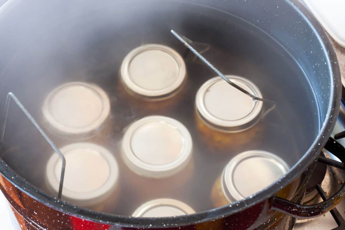 Making peach jam by boiling it inside a huge pot