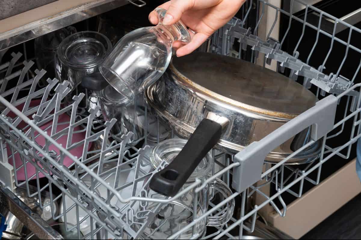 Placing a used glass into the dishwasher