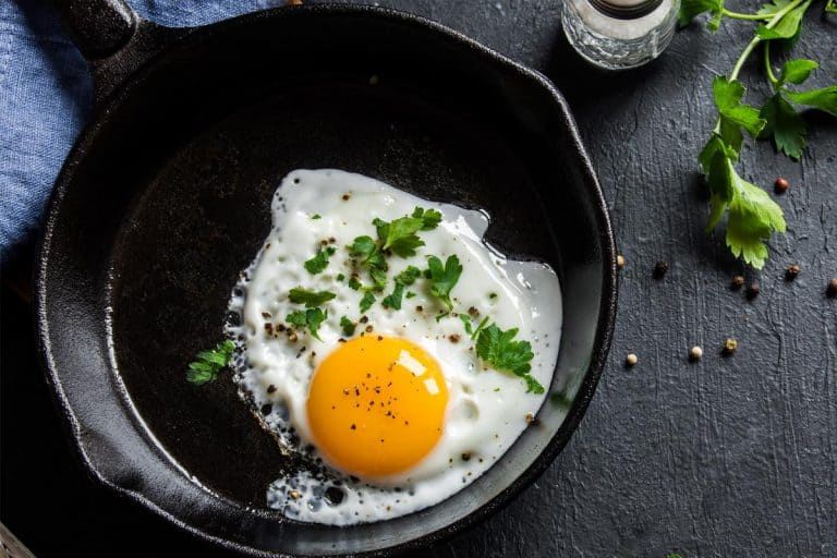 Salted and spiced fried egg with parsley on cast iron pan, 3 Of The Best Pans For Cooking Eggs