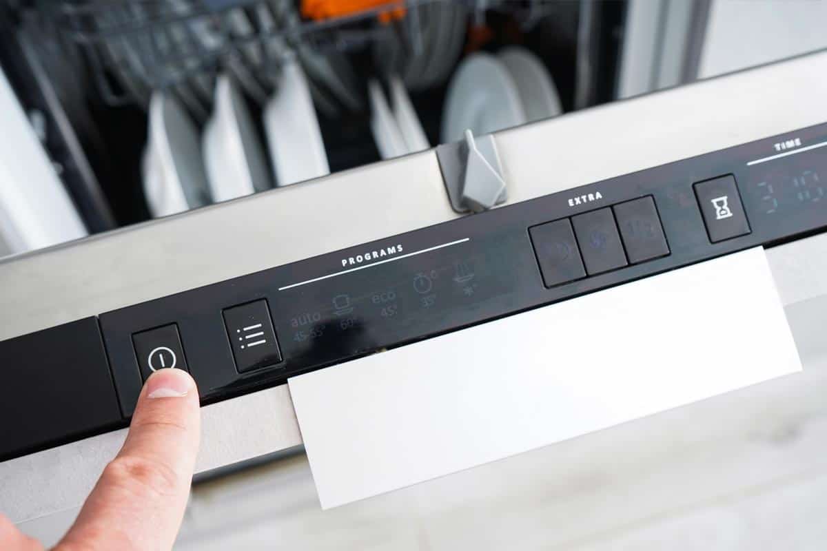 The man puts dirty dishes in the dishwasher, How To Reset An Amana Dishwasher