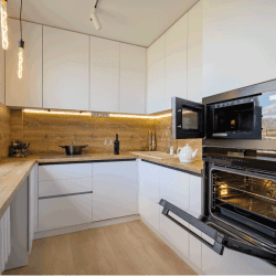 Well-designed-white-and-wooden-beige-modern-kitchen-interior-with-oven-door-opened.-Should-You-Leave-The-Oven-Door-Open-After-Baking