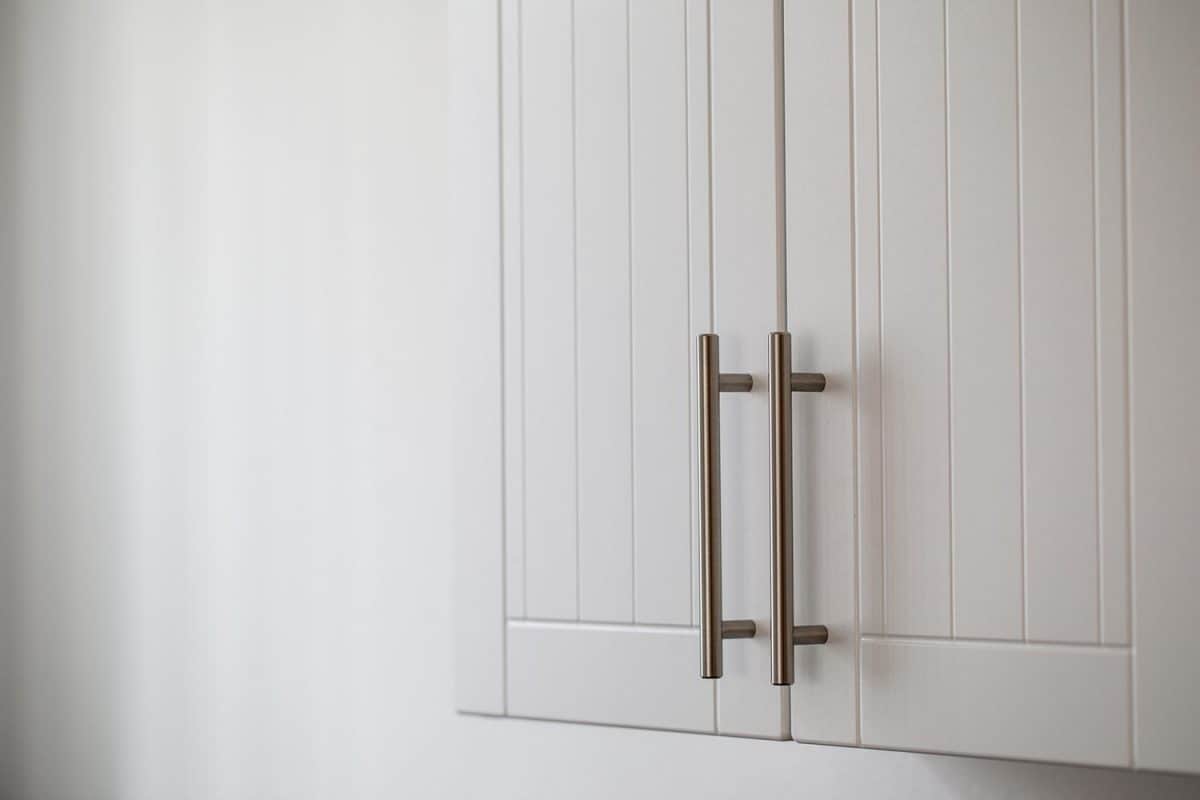 White kitchen cabinets with metal pulls or knobs on the doors