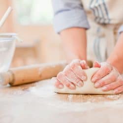 Woman kneading dough on kitchen counter, Can You Make Bread Without A Stand Mixer?