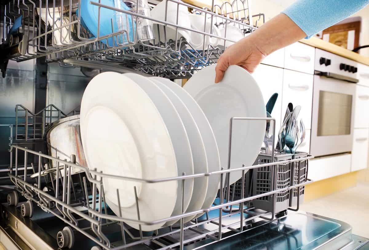 Woman removing plate on the dishwasher