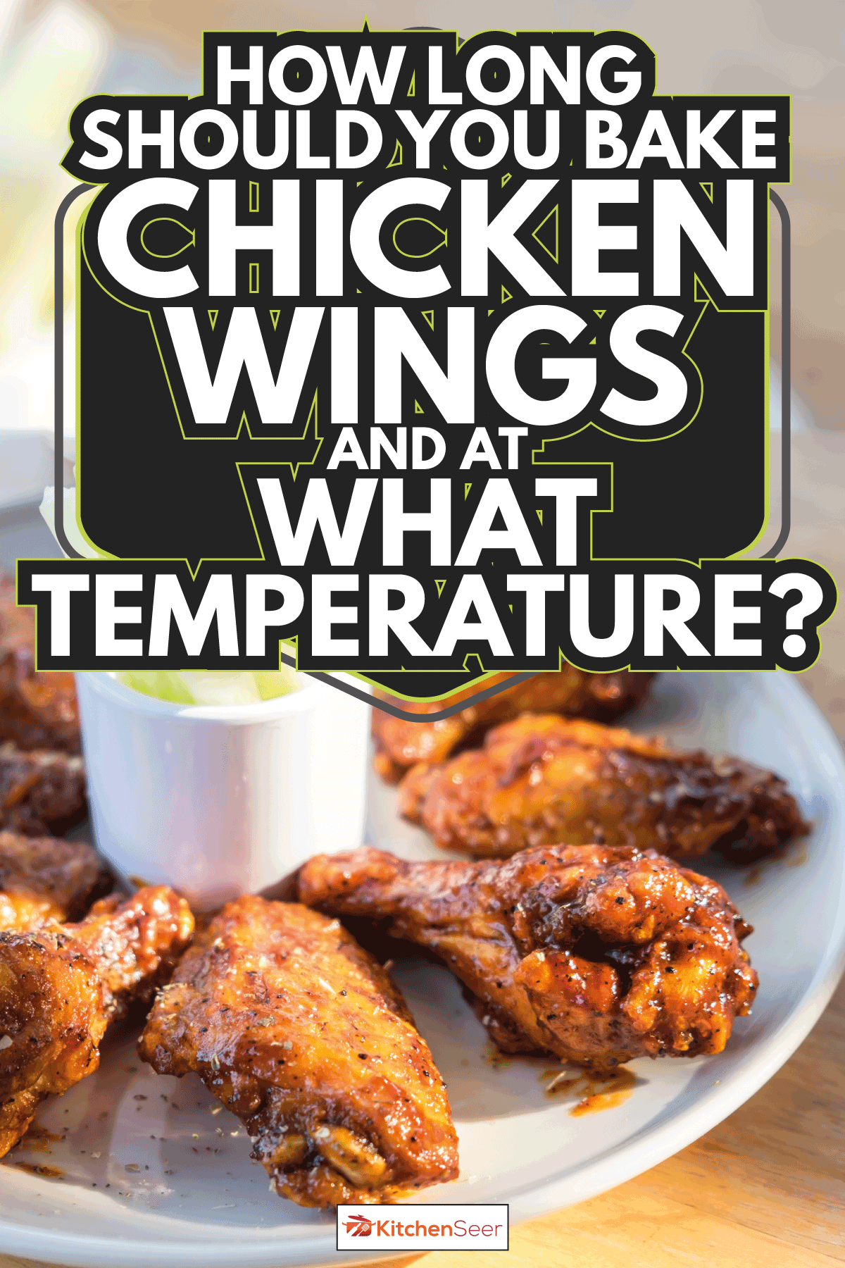 chicken wings buffalo style on a white plate with sliced pickles. How Long Should You Bake Chicken Wings And At What Temperature