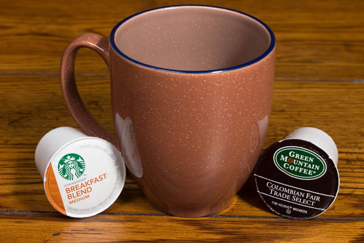 A coffee mug and two K cups on the table