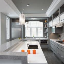 A luxurious and modern inspired kitchen with gray flooring, white countertops and gray cabinets and white cupboards, What Color Kitchen Cabinets Go With Gray Floors?