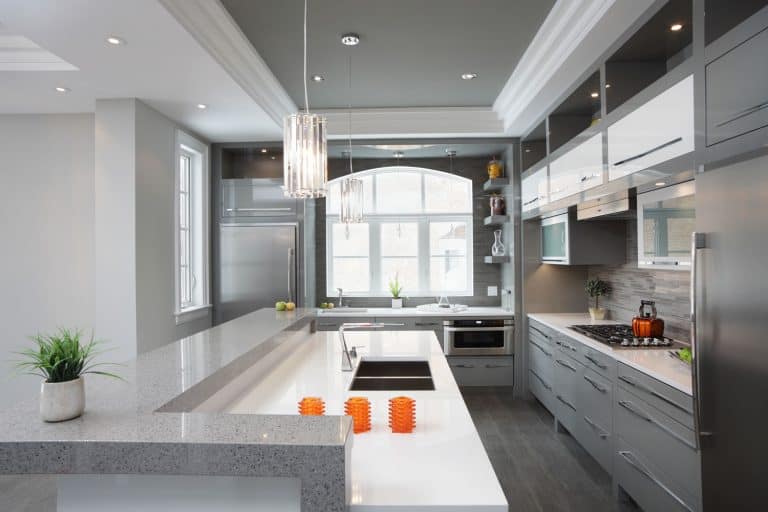A luxurious and modern inspired kitchen with gray flooring, white countertops and gray cabinets and white cupboards, What Color Kitchen Cabinets Go With Gray Floors?