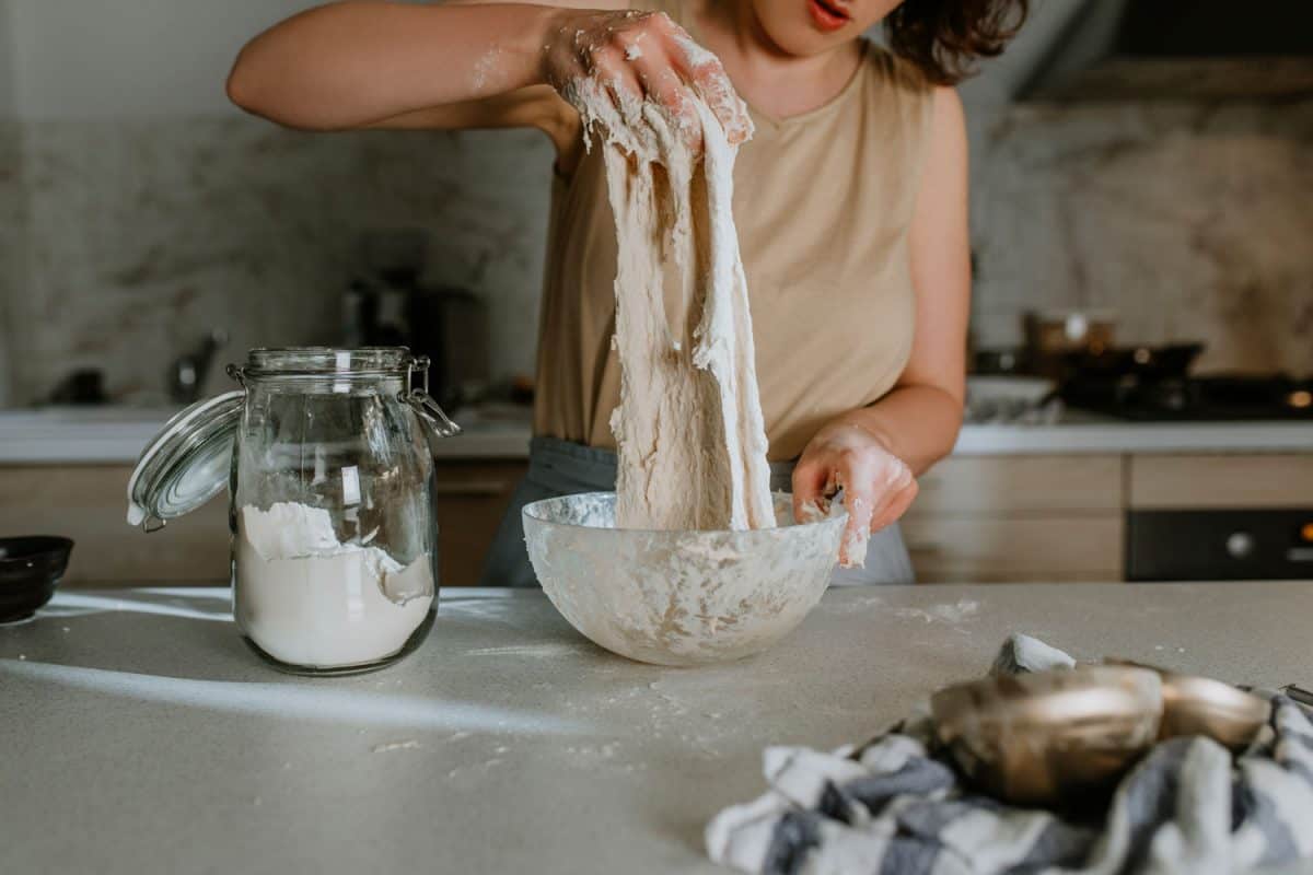 A woman mixing together ingredients for a Sourdough bread