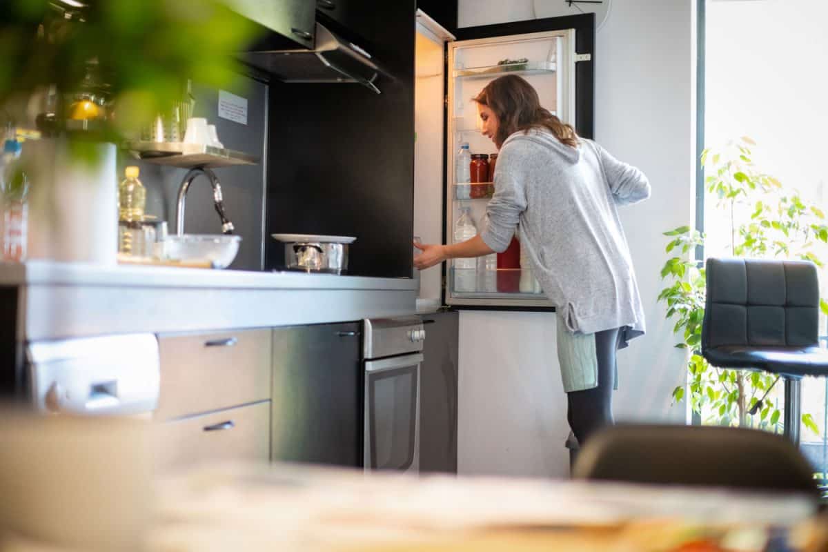 A woman opening the fridge for food