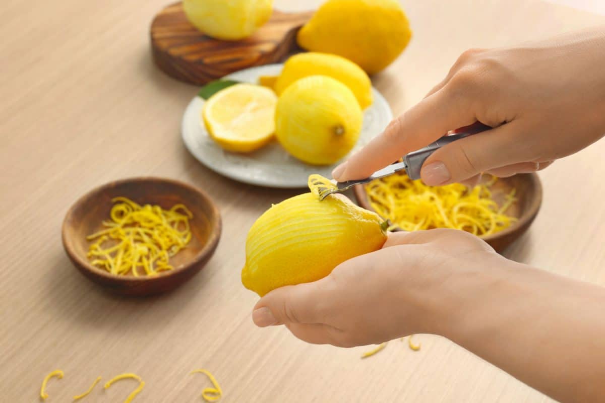 A woman peeling lemons, Can You Put Lemons Or Lime In The Garbage Disposal?