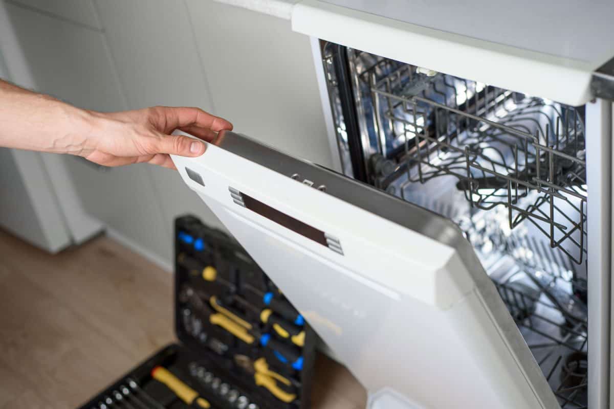 A home service repairman opening the dishwasher