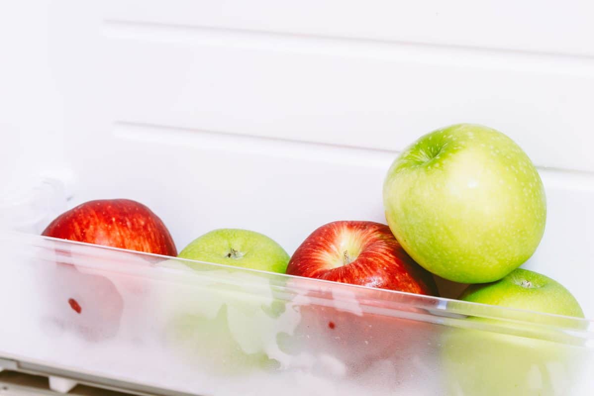 Apple in open empty refrigerator ideal for diet