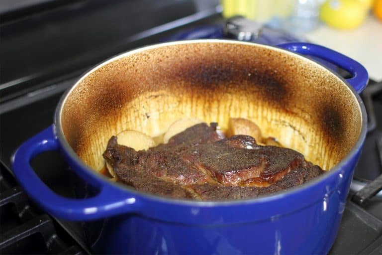 Beef pot roast in a Dutch oven baked with onions and potatoes, How To Clean An Enamel Dutch Oven [A Complete Guide]