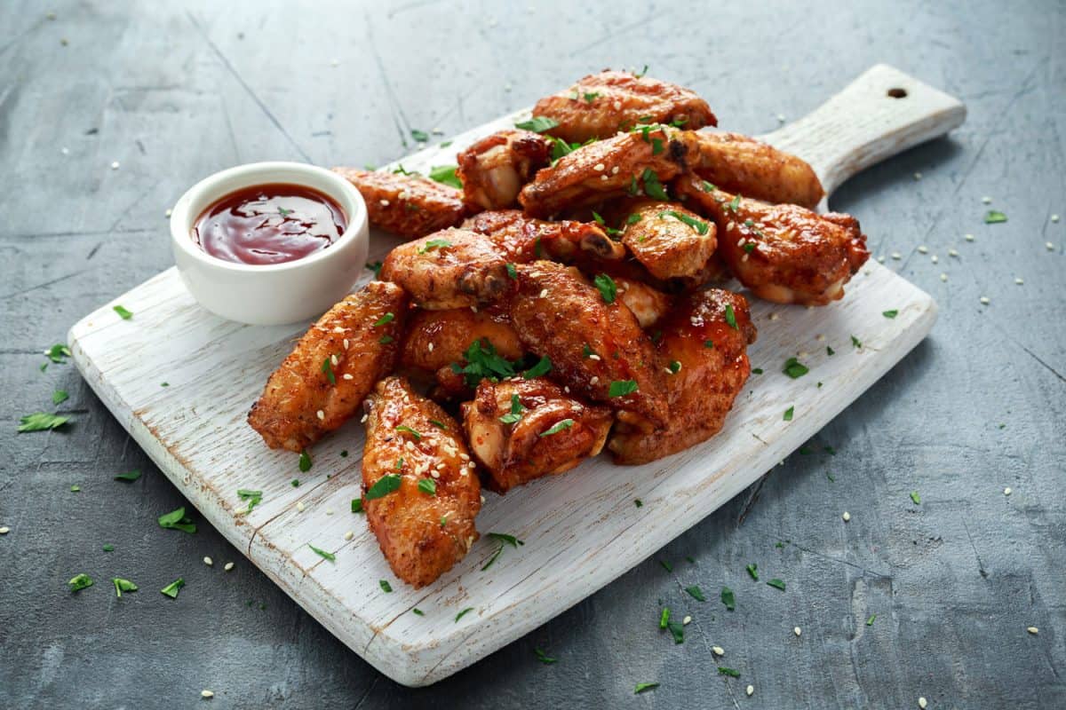 Chicken wings garnished with chives and ketchup dip on the side