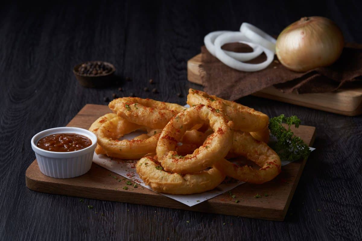 Deep fried onion rings with a ketchup dip on the side