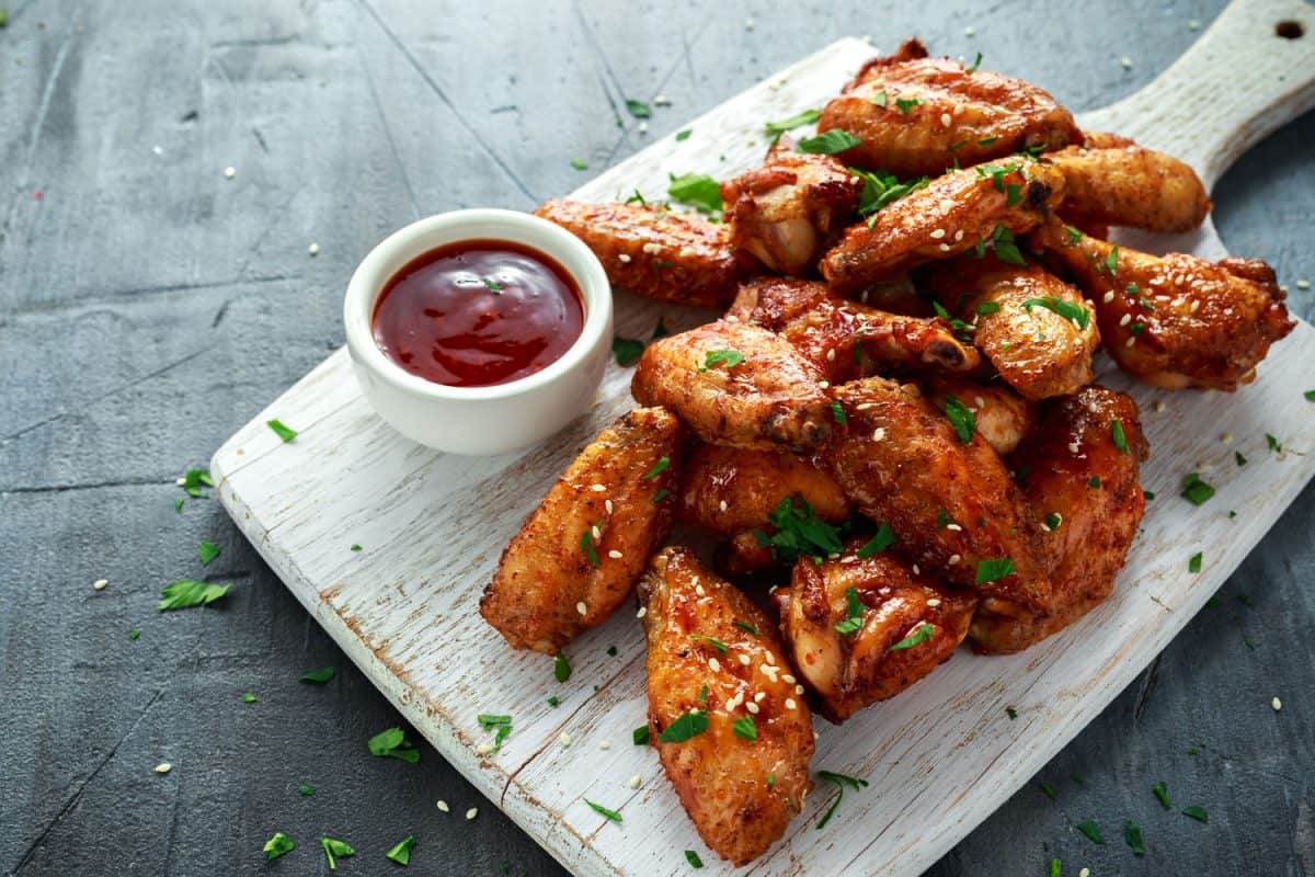 Delicious chicken wings and drumsticks garnished with chives and sesame seeds