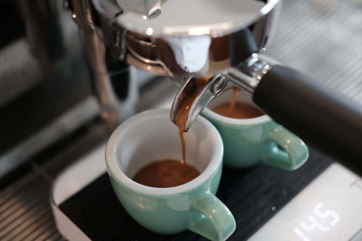 Espresso extraction by professional espresso machine at coffee shop