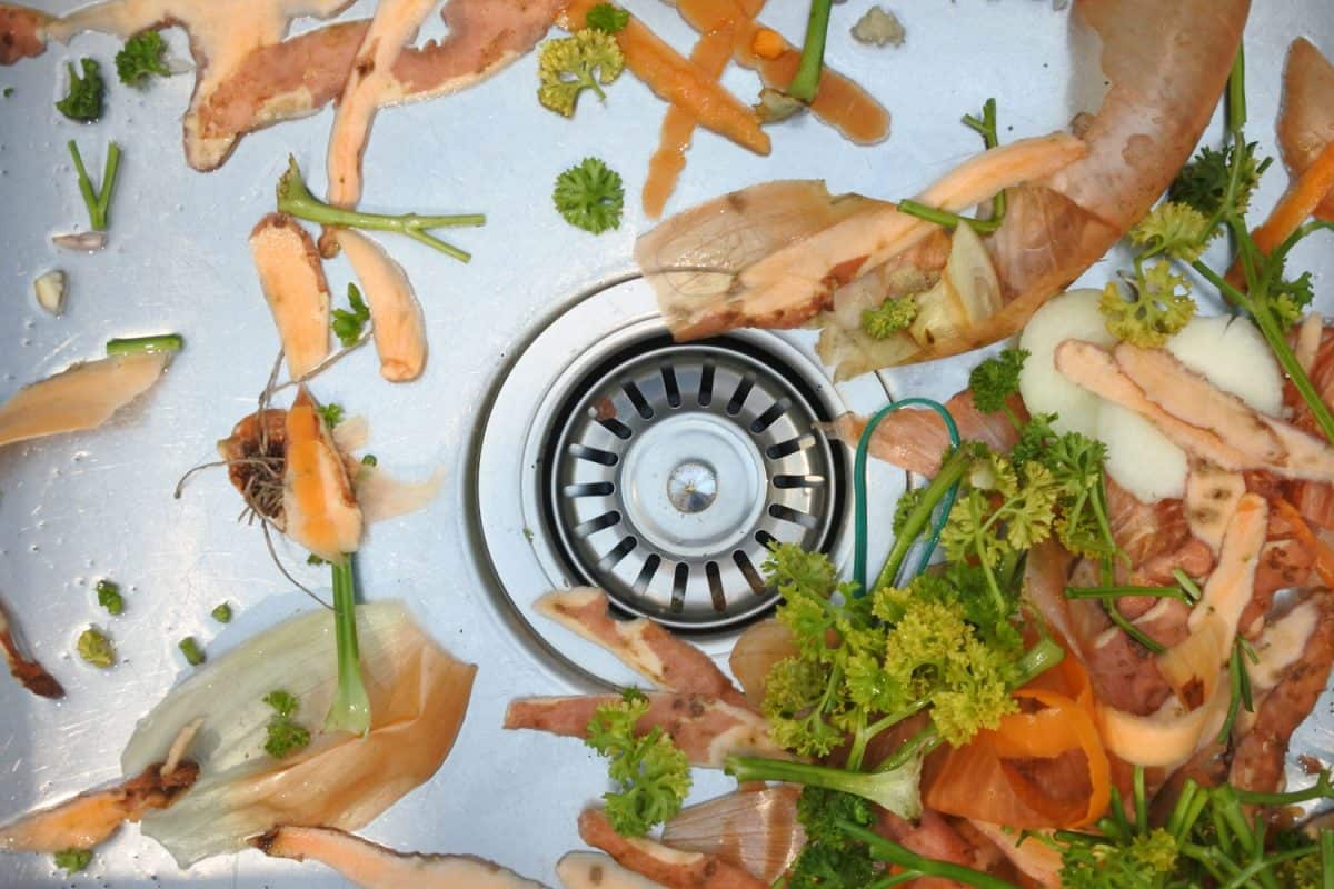Flat lay view of mix of vegetables waste in home kitchen sink. Food background and texture