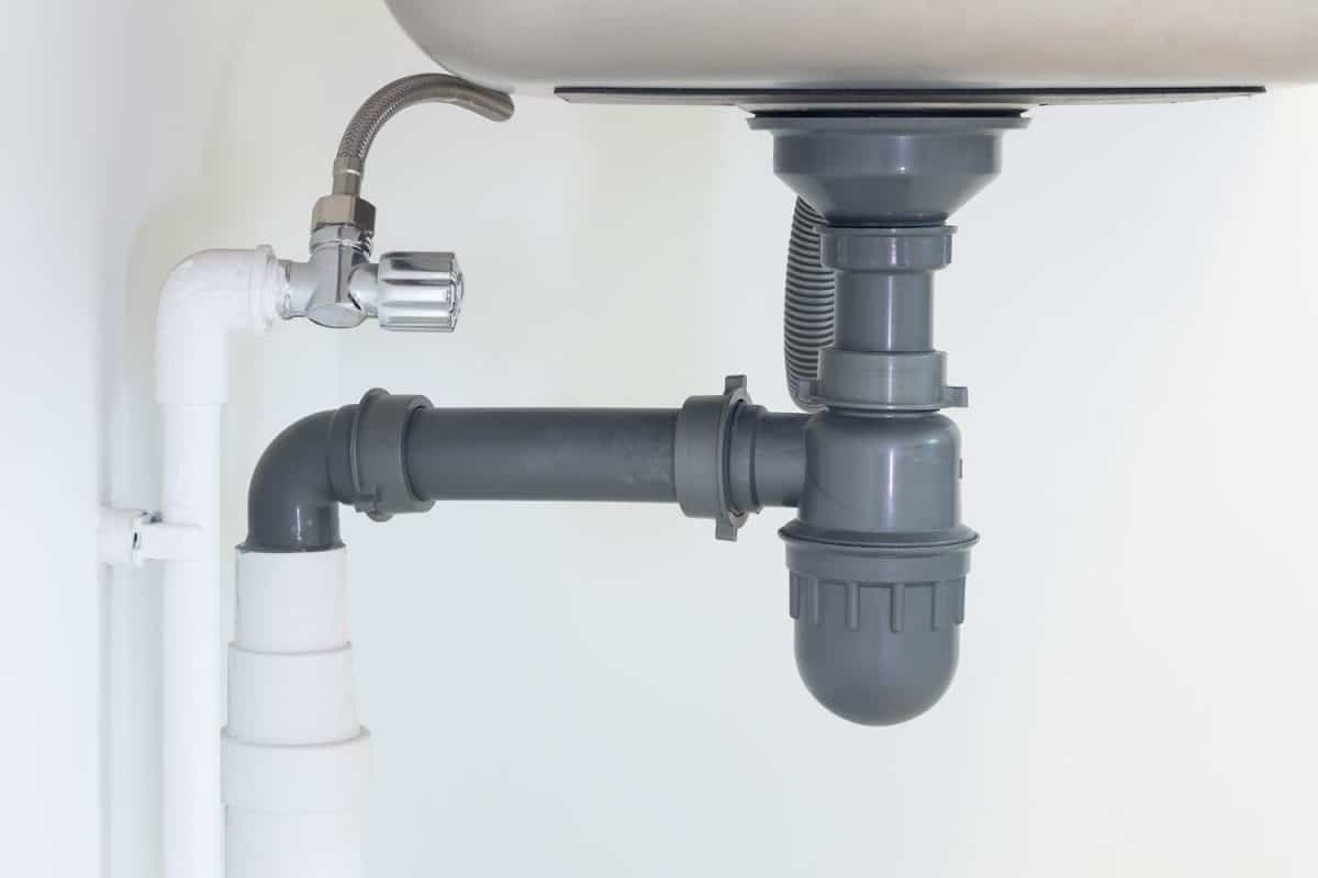 Gray PVC pipe for the kitchen sink under the kitchen