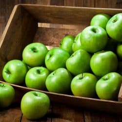 A green apples in a crate on rustic wood table, Can You Eat Granny Smith Apples Raw? [Including On An Empty Stomach]