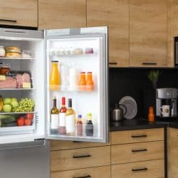 Open refrigerator full of products in kitchen, Do Whirlpool Refrigerators Require A Stabilizer?