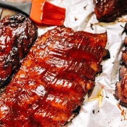Ribs glazed with sauce on aluminum foil, Should You Wrap Ribs in Foil When Baking?