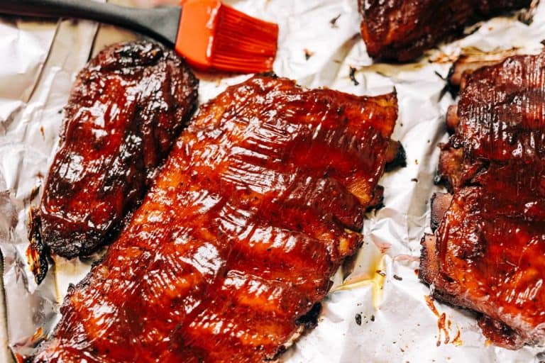 Ribs glazed with sauce on aluminum foil, Should You Wrap Ribs in Foil When Baking?
