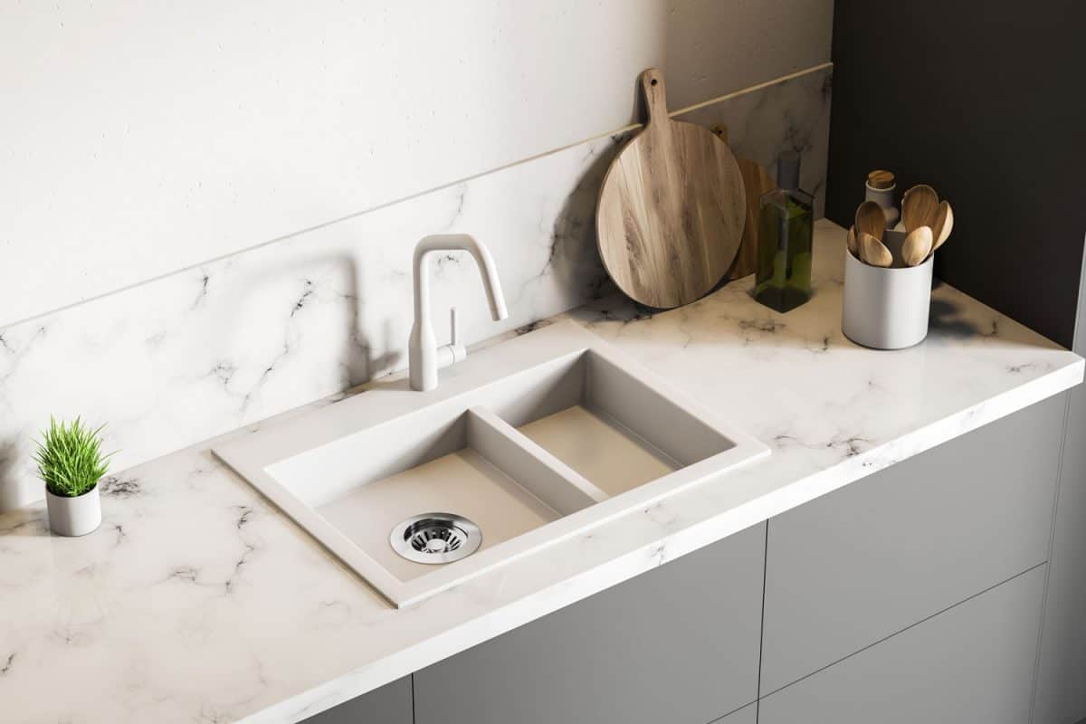 Top view of white marble kitchen sink standing on gray countertop in room with white walls, Should Kitchen Sink Match Countertops?