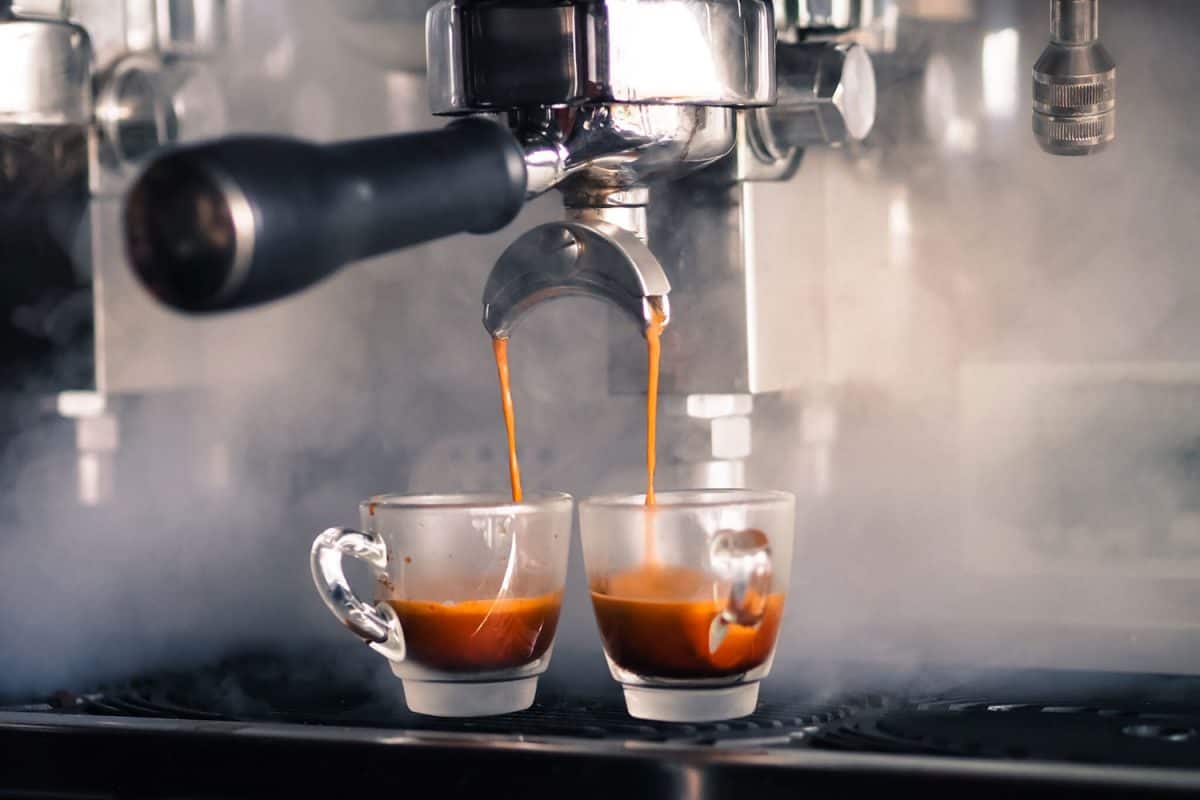 Two glasses of coffee cups being poured with sweet aromatic freshly brewed coffee