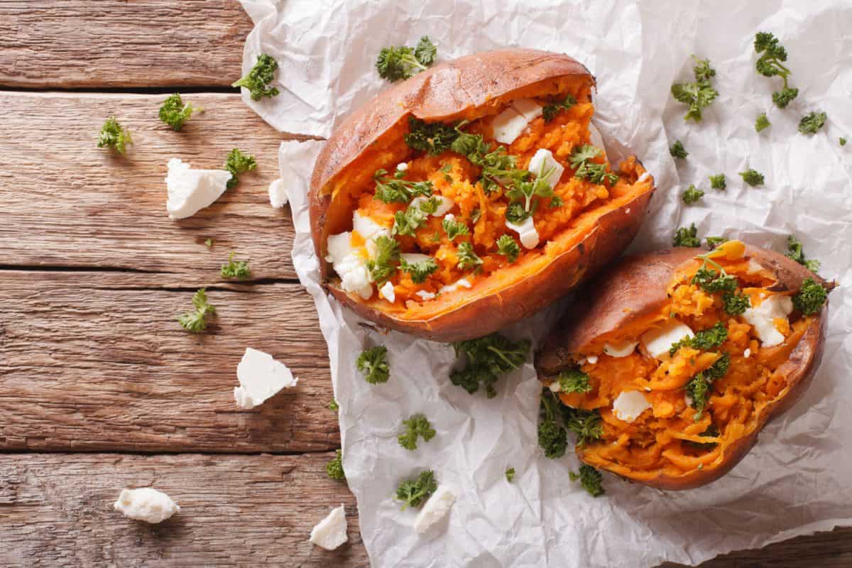 sweet potatoes baked with feta cheese and parsley on the table