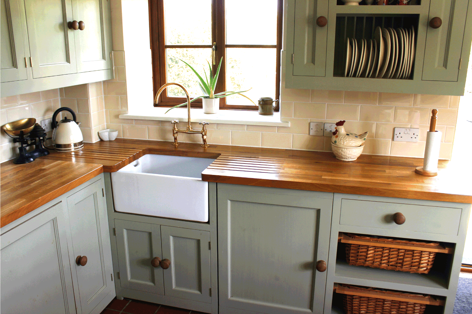  traditional country kitchen, with a large range cooker with gas hob, duck egg green cupboards and wall cabinets, a white ceramic sink