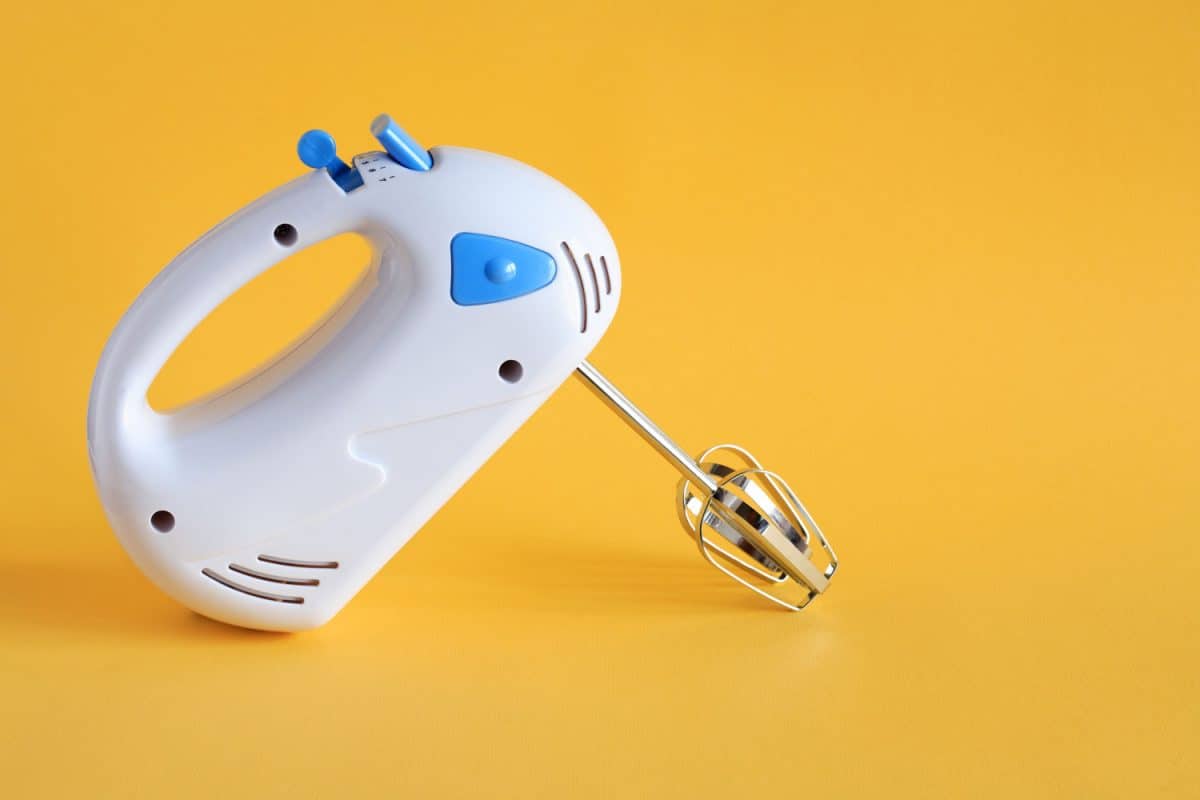 A blue and white colored hand mixer on a yellow background, How To Take Apart A Cuisinart Hand Mixer