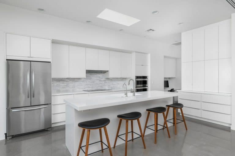 A white minimalistic modern contemporary kitchen with white cupboards and cabinets, Does A Refrigerator Need Water Line? [And How To Install One]