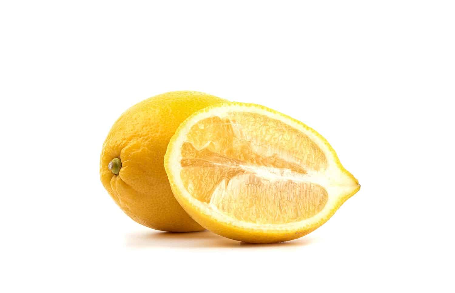 A whole lemon and half of the fruit cut lengthwise on a white background.