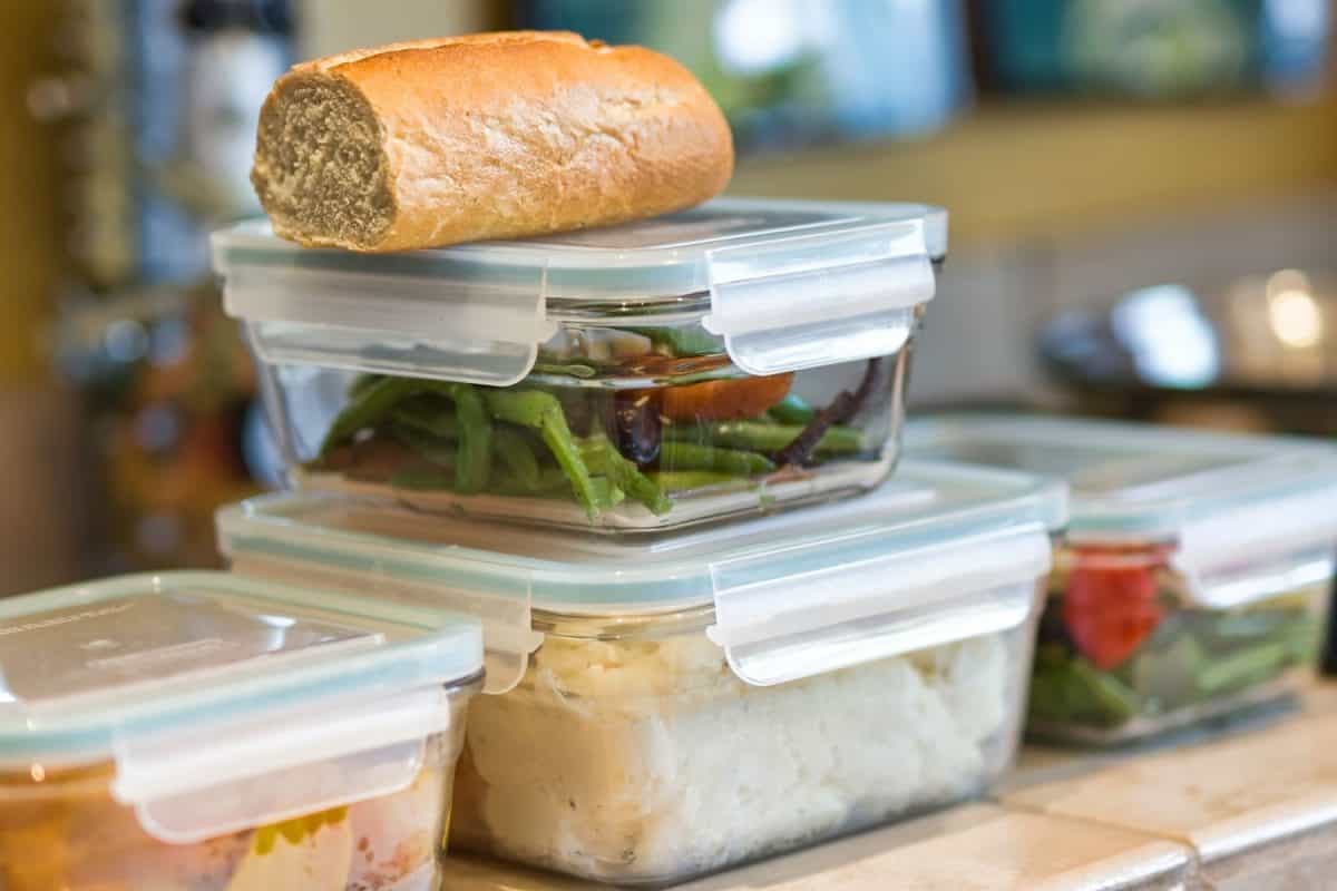 Containers of leftover food stacked on kitchen counrter