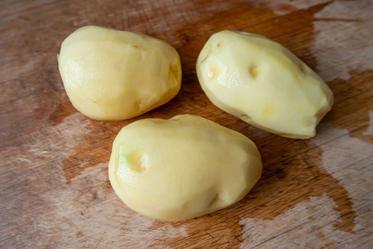 Fresh potatoes on wooden kitchen board