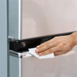 Hands of young Asian woman cleaning stainless steel refrigerator with wet wipe tissue at home, How To Remove Scratches From Stainless Steel Refrigerator Door