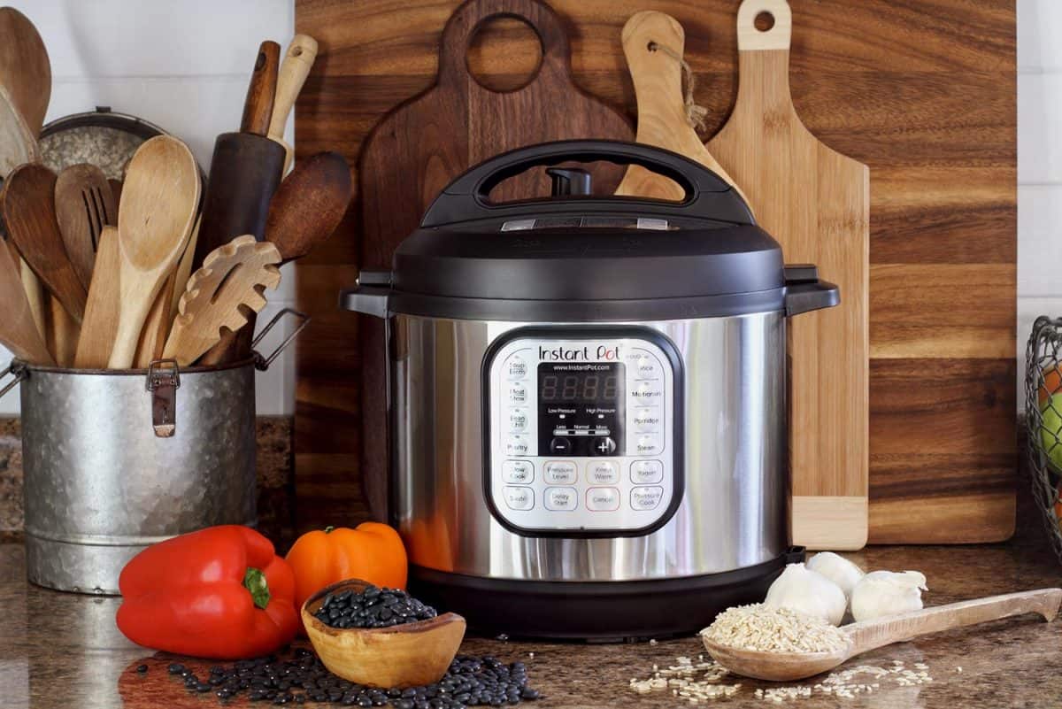 Instant Pot pressure cooker on kitchen counter with beans and rice