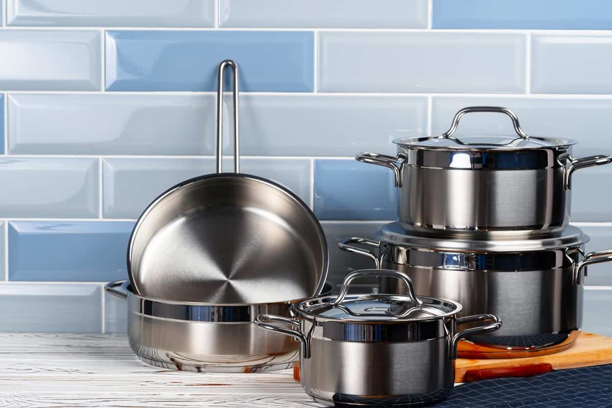 Set of aluminum cookware on kitchen counter, Can Cuisinart Pans And Pots Go In The Oven? [Inc. The Lids]